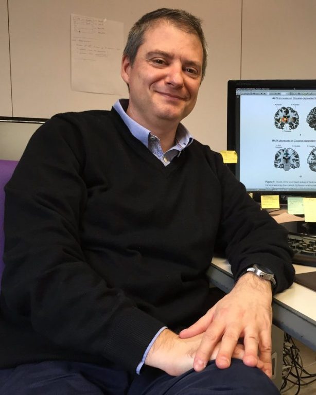 Dr. Jordi Riba sitting in front of a computer with mri images on the screen.