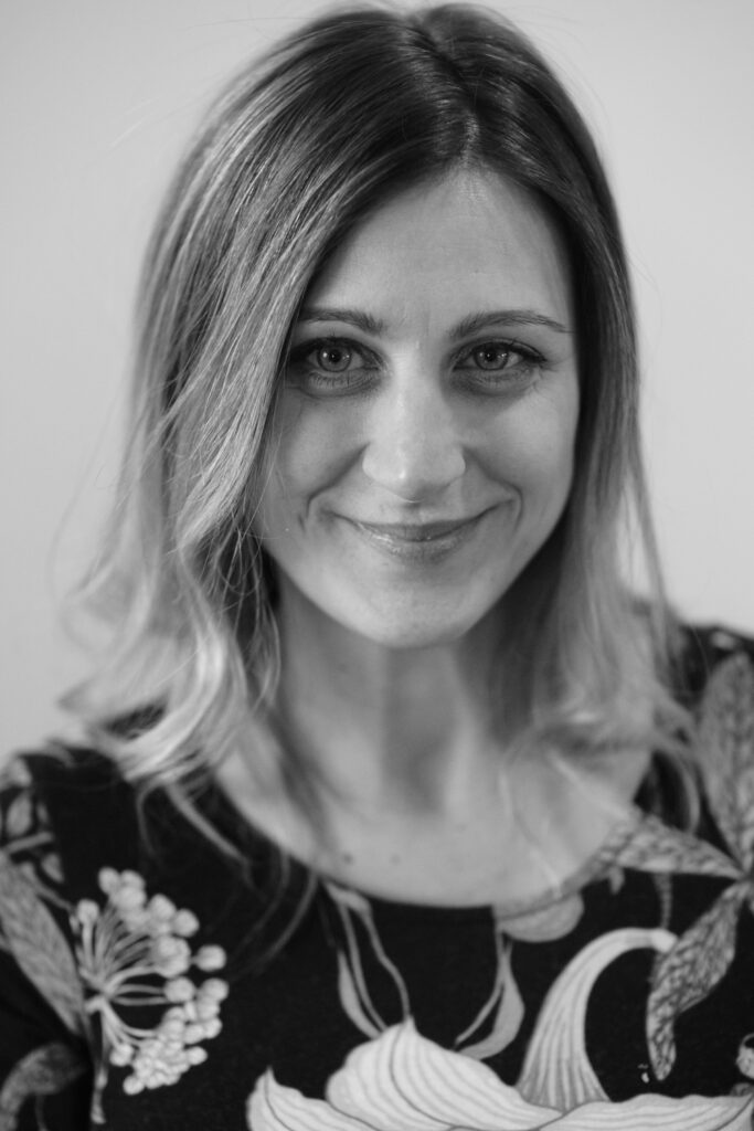 A black and white photo of a woman smiling.