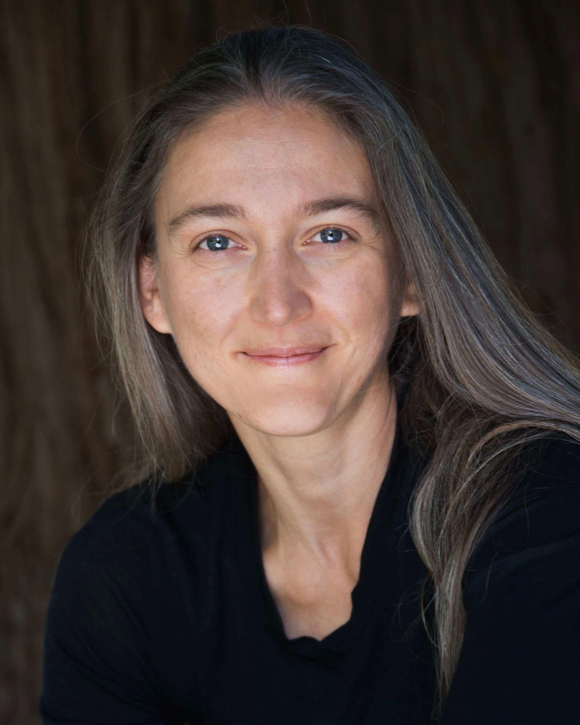 Dr. Monica Gagliano wearing a black shirt and smiling.